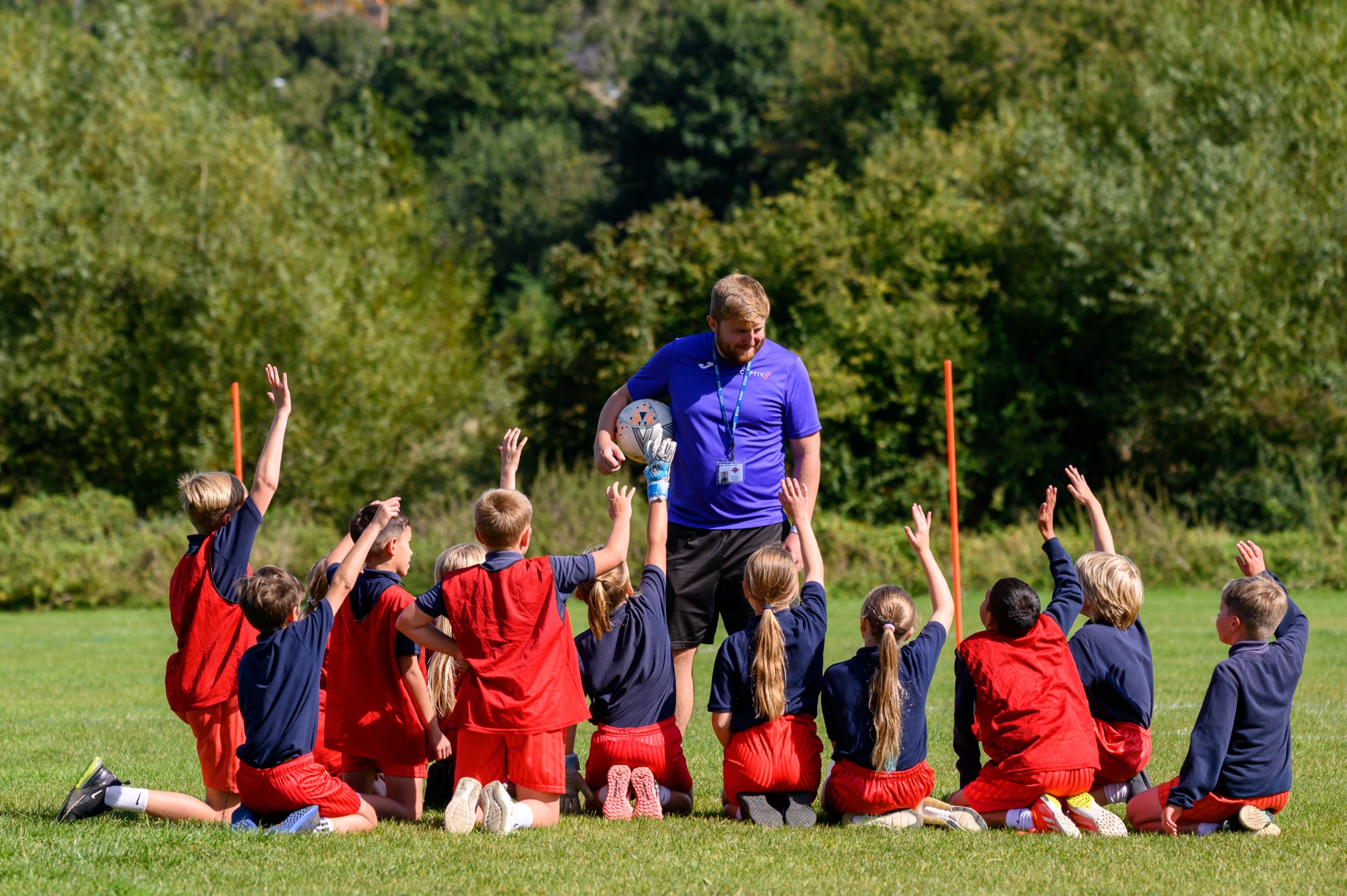 Children on field with Sports Coach 